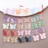 Variedad de cuentas de mariposa de vidrio de colores en tonos pastel y tamaños