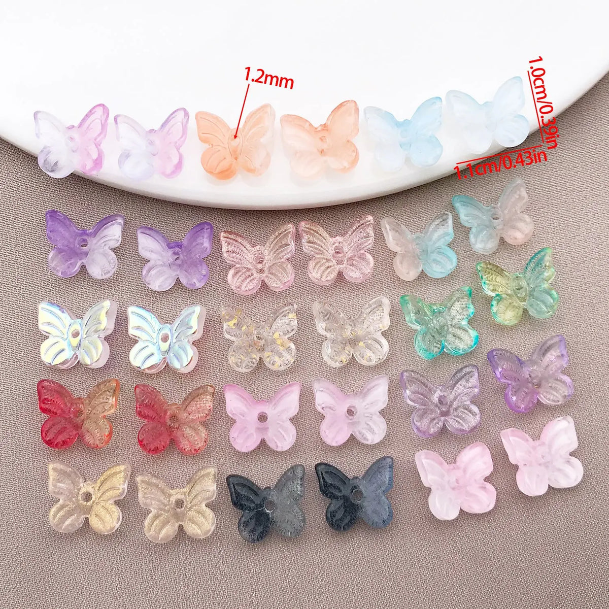 Variedad de cuentas de mariposa de vidrio de colores en tonos pastel y tamaños