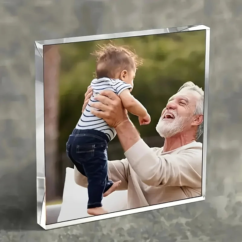 A framed photo of a man holding a baby, featuring a personalized acrylic ornament.