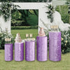 Four purple spandex cylinder stands with floral tops and gold sticks for wedding and event decor
