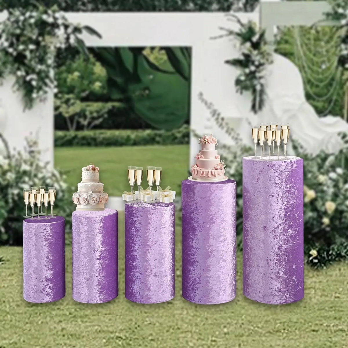 Four purple spandex cylinder stands with floral tops and gold sticks for wedding and event decor