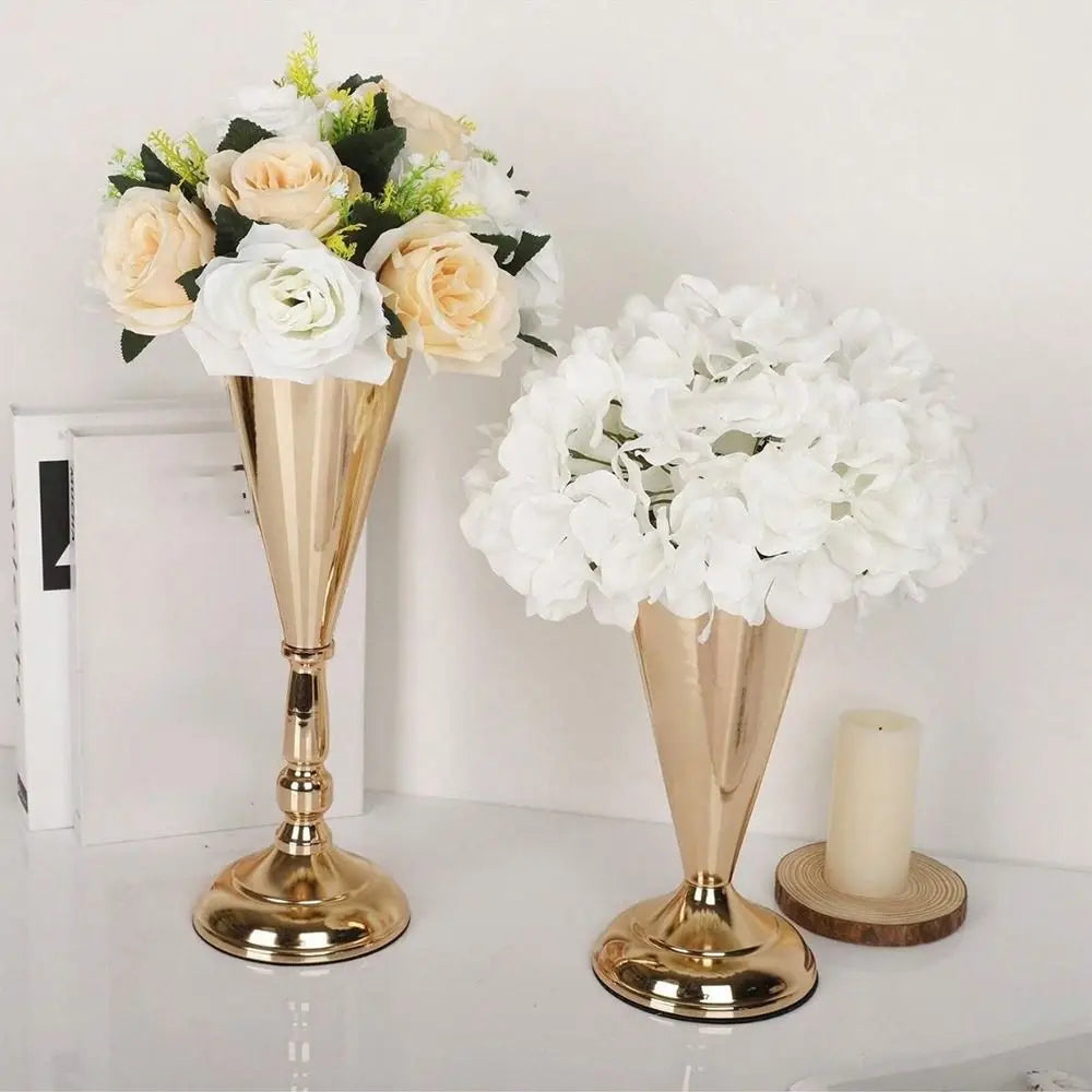 A display of elegant golden silver wedding flower vases with white and cream roses and hydrangeas.