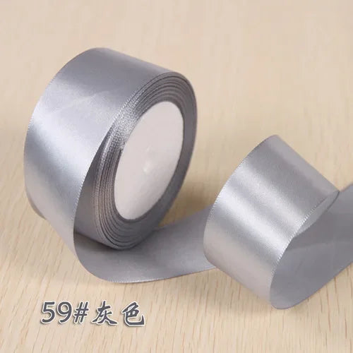 Roll of silver satin ribbon used for gift wrapping and craft projects