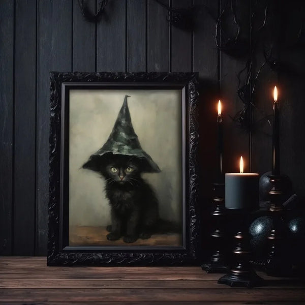 A dark framed canvas print featuring a black cat wearing a witch hat against a muted background.