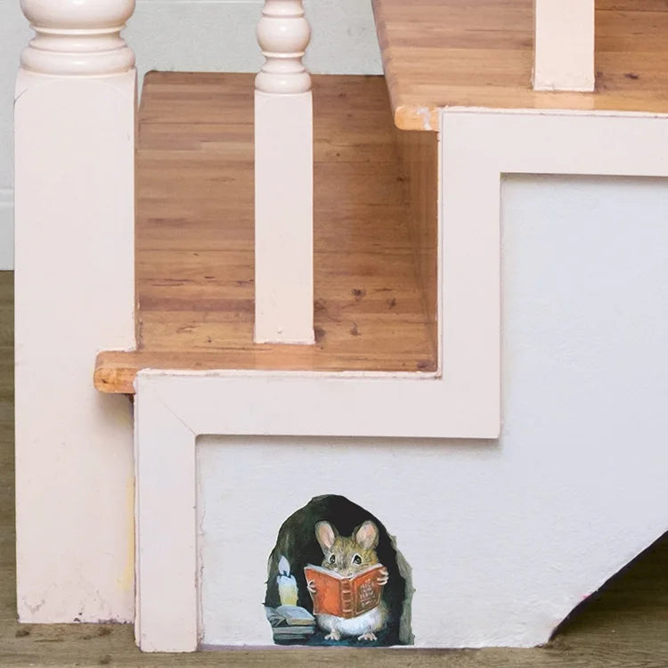 A cartoon mouse is sitting on a white wall ledge reading a book in a room with wooden stairs.
