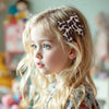 Une fille blonde vue de profil portant des pinces à cheveux à imprimé léopard.