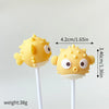 A set of yellow ocean animal cake toppers, including a whale and an octopus, mounted on white sticks.
