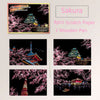 A set of four scratch paper cards featuring cherry blossom scenes and a wooden pen for DIY painting art kit