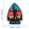 An embroidered patch featuring a silhouette of Bigfoot against a sunset background with horizontal stripes.