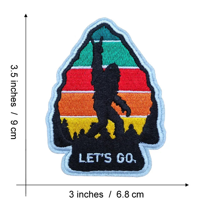 An embroidered patch featuring a silhouette of Bigfoot against a sunset background with horizontal stripes.