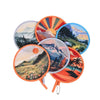 A collection of round, colorful, handheld cooling fans featuring scenic landscape designs.