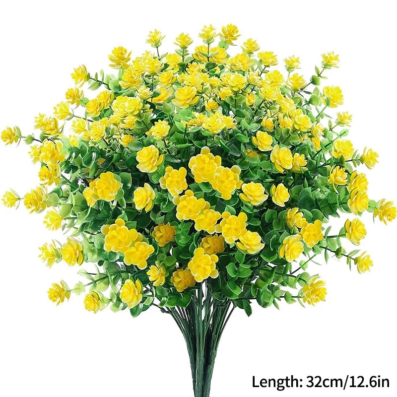 Un bouquet de fleurs artificielles d'automne et d'Halloween jaunes avec du feuillage vert.