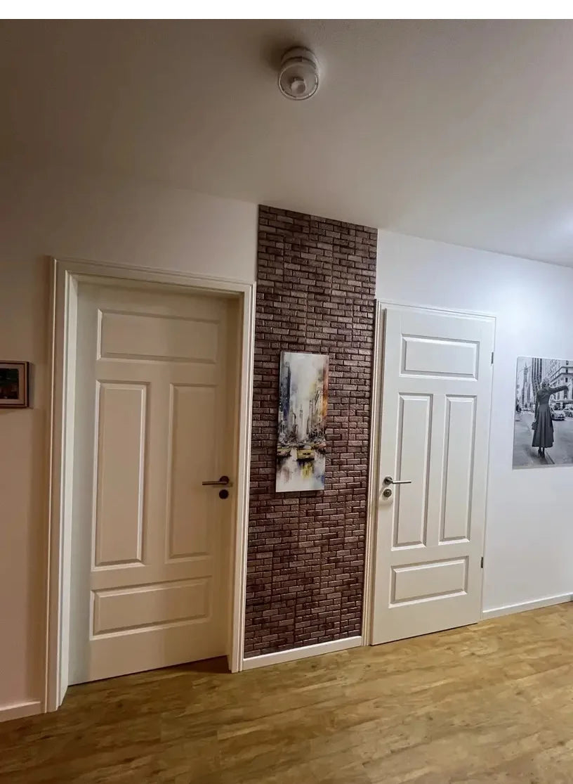 A white paneled door next to a textured brown brick wall featuring an abstract artwork.
