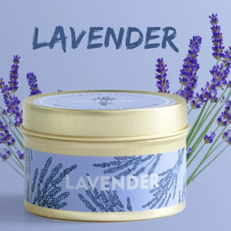 A jar of lavender scented soy wax travel candle with a gold lid and purple lavender sprigs in the background.