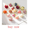 A collection of artificial rose-colored eucalyptus leaves in various shades of pink, red, and green arranged on white paper.