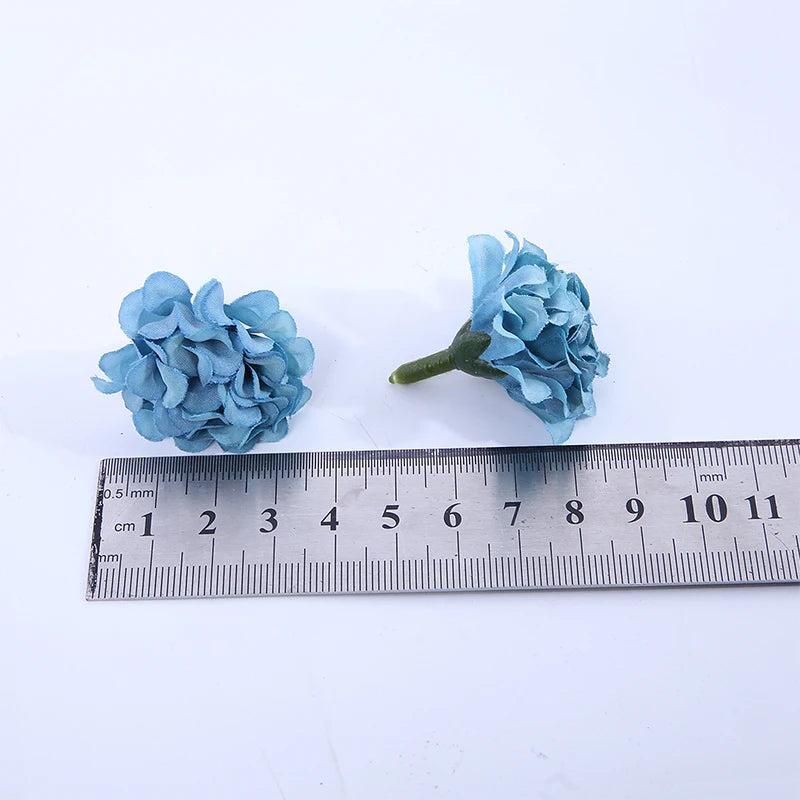 Un amas de fleurs artificielles bleu hydrangee à côté d'une règle pour l'échelle.