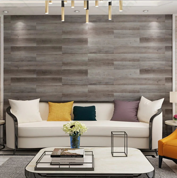 A modern living room featuring a gray wood grain accent wall, a white sofa, and a light-colored coffee table.