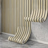 A roll of self-adhesive wood grain wallpaper featuring vertical stripes in beige and black tones mounted on a wall.