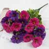 A bouquet of artificial pansy flowers in shades of purple and pink with green eucalyptus stems.