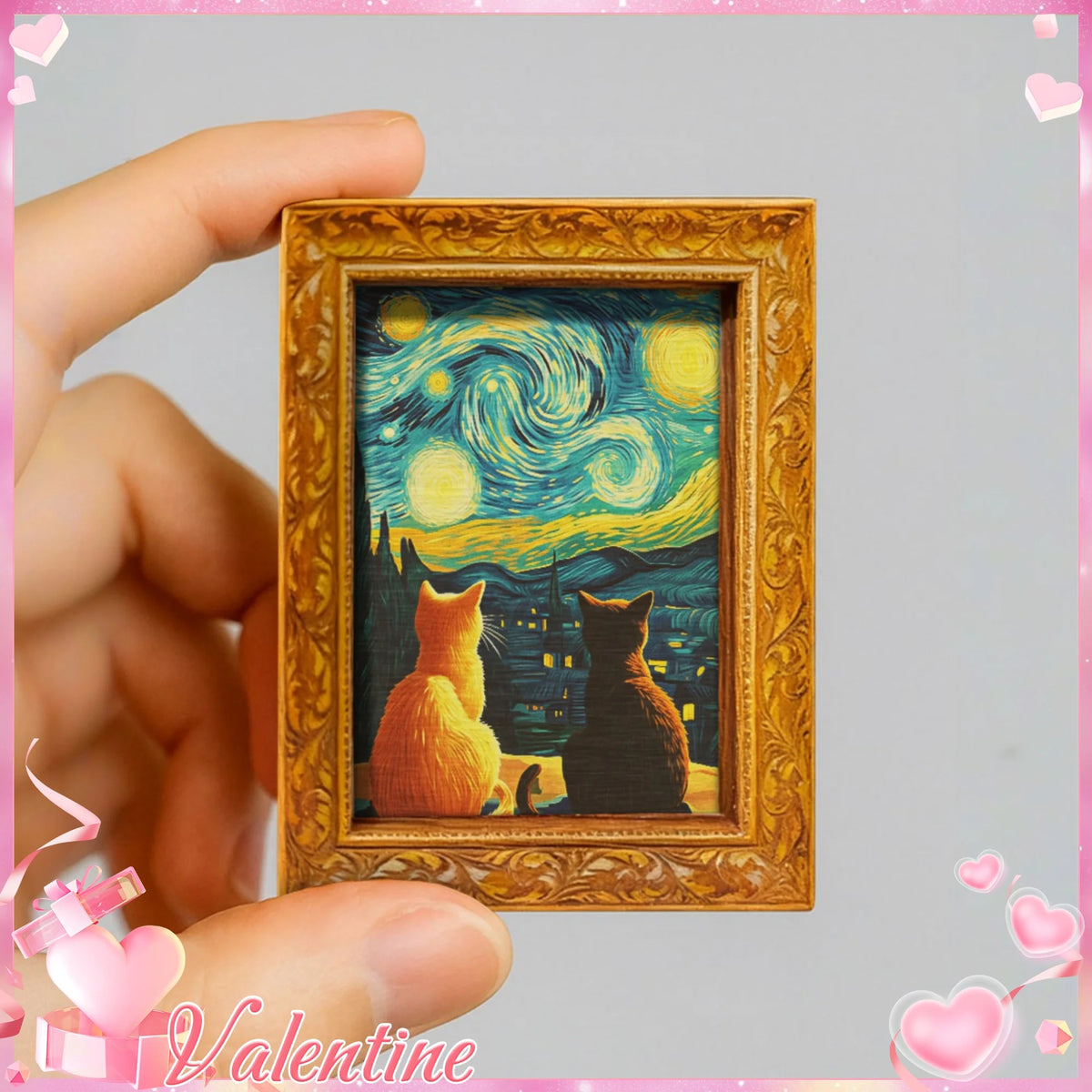 A framed print featuring a Van Gogh starry sky with two cats, held by a hand.