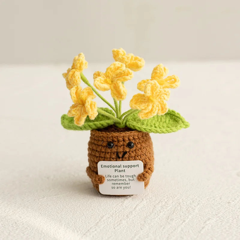 Handmade crochet sunflower desk companion with a smiling face, featuring yellow flowers and green leaves.