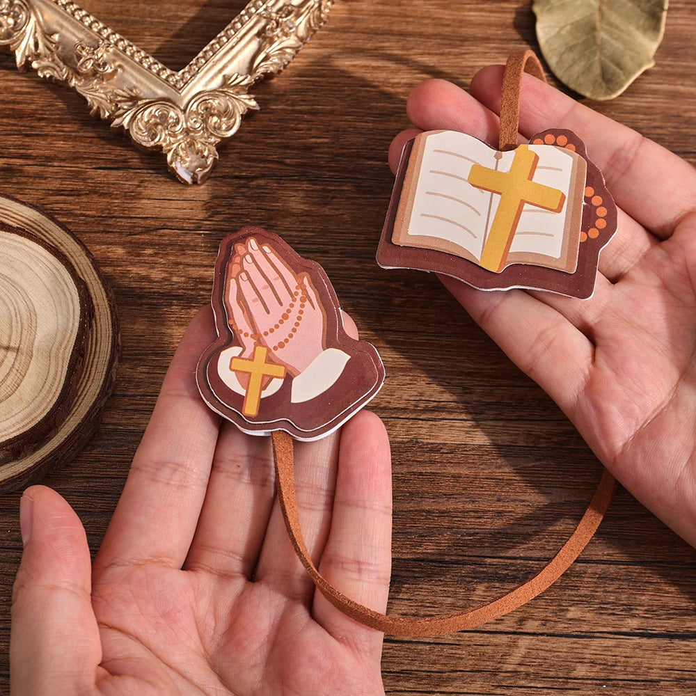 Marcador de Biblia de cuero sintético marrón con un diseño de las manos de Jesús y una cruz, sostenidas en la mano de una per