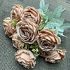 A bouquet of nine realistic silk roses in soft beige and dusty rose tones with green foliage.