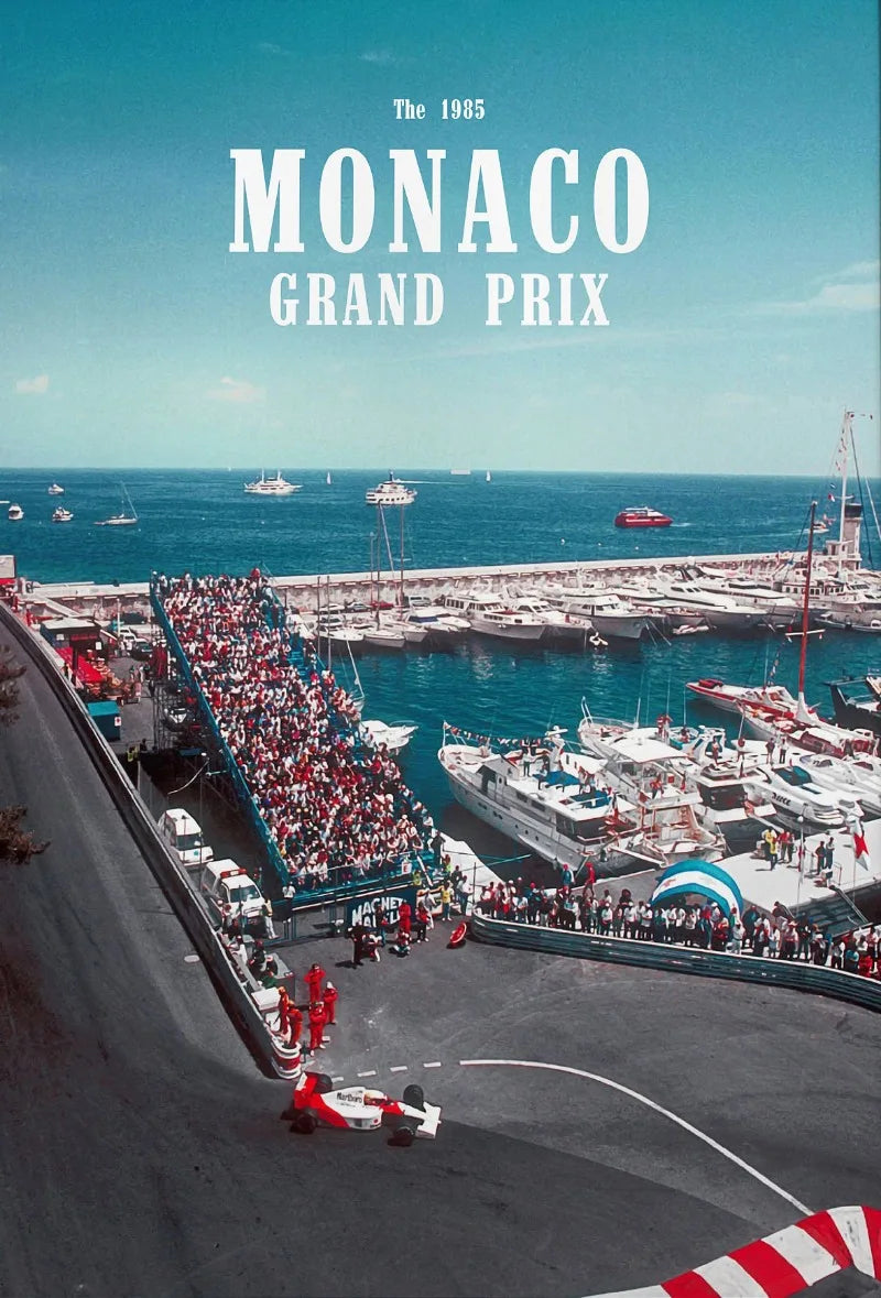 A vintage photograph of the 1985 Monaco Grand Prix race, showing a car on a track and spectators along the barrier.