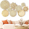 Boho straw wall hanging featuring woven textures and tassels displayed on a white wall.