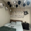 Silver alphabet and heart balloon set hanging above a bed for birthday party decorations