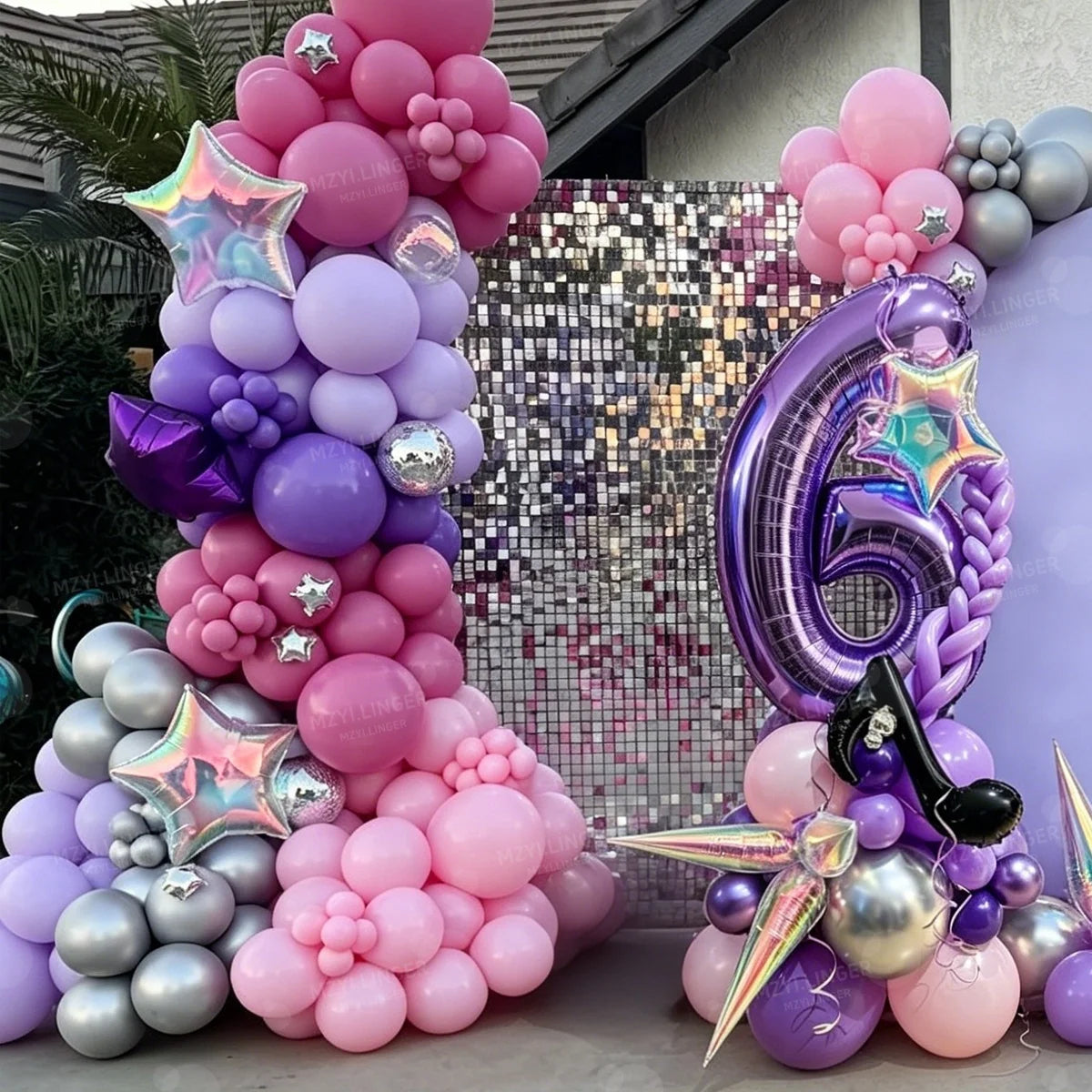 A colorful balloon column set featuring pink, purple, and silver balloons arranged in a tiered display.