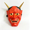 A vibrant orange Japanese Hannya demon mask with horns and fierce facial features.