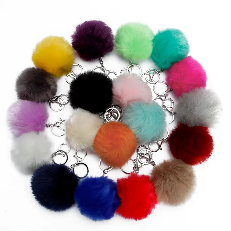 A collection of colorful faux fur pom pom keychains attached to silver chains.