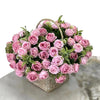 A bouquet of pink and mauve artificial roses in a woven basket for wedding decoration
