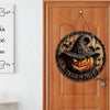 Panneau décoratif d'Halloween en bois rond avec un visage de citrouille sculpté et un chapeau de sorcière suspendu sur une po