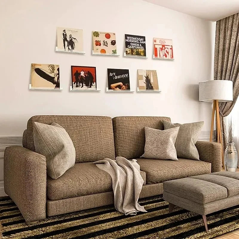 A living room display featuring clear acrylic floating record shelves mounted on a white wall.
