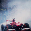A red Formula 1 race car is kicking up smoke on the track during a race.
