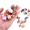 A hand holds several small, colorful articulated 3D animal figurines for desk decor.