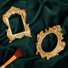 A vintage gold DIY shadow box frame with ornate detailing is displayed on a dark green fabric.