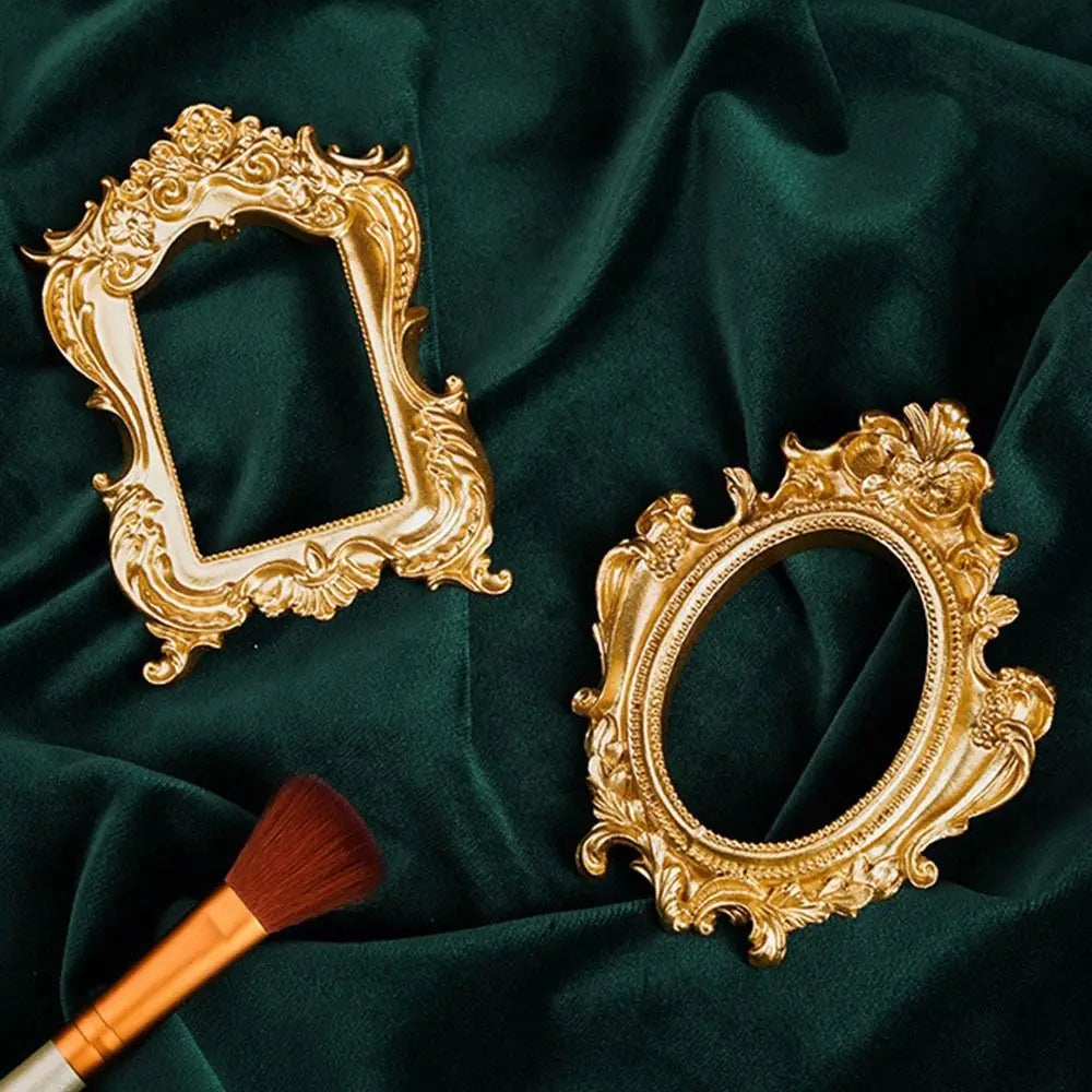 A vintage gold DIY shadow box frame with ornate detailing is displayed on a dark green fabric.