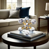 A minimalist molecular sculpture desk decor featuring gold-toned spheres with clear, sparkling glass orbs on a dark wooden ta