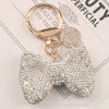A sparkling rhinestone bow keychain with a gold-toned clasp and chain.