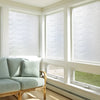 A light blue sofa is visible in a bright room with large windows covered by white frosted glass privacy film.