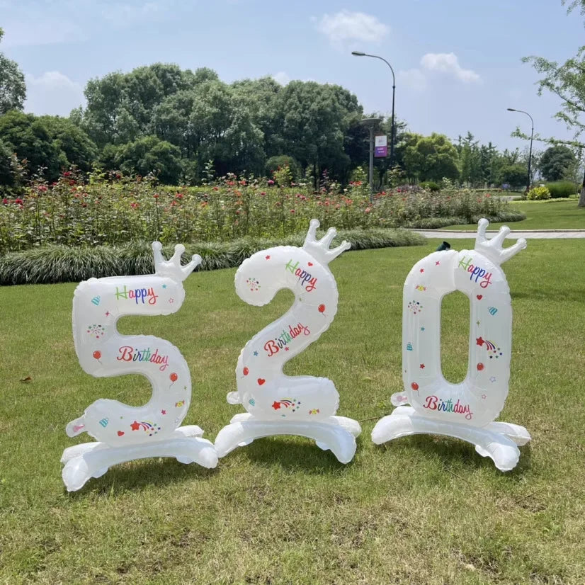 White standing foil balloon numbers 520 with crowns and birthday text set outdoors