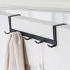 A black iron door and wall organizer rack with five hooks mounted on a white surface.