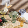 A collection of mushroom-shaped glass vases in translucent jelly colors, including green and amber tones.