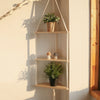Étagère flottante en bois bohème affichant des plantes en pot et de petits objets décoratifs.
