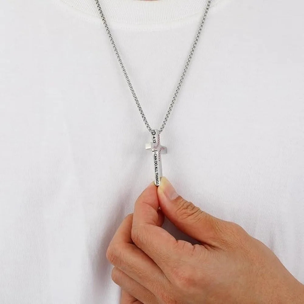 A stainless steel cross pendant necklace with a baseball pattern design worn on a white shirt.