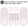 A set of pink bow disposable party tableware including 7 inch and 9 inch plates, cups, and napkins.
