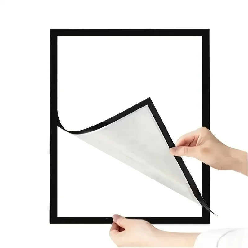 A hand is holding a white photo print, demonstrating the magnetic self-adhesive photo frame.